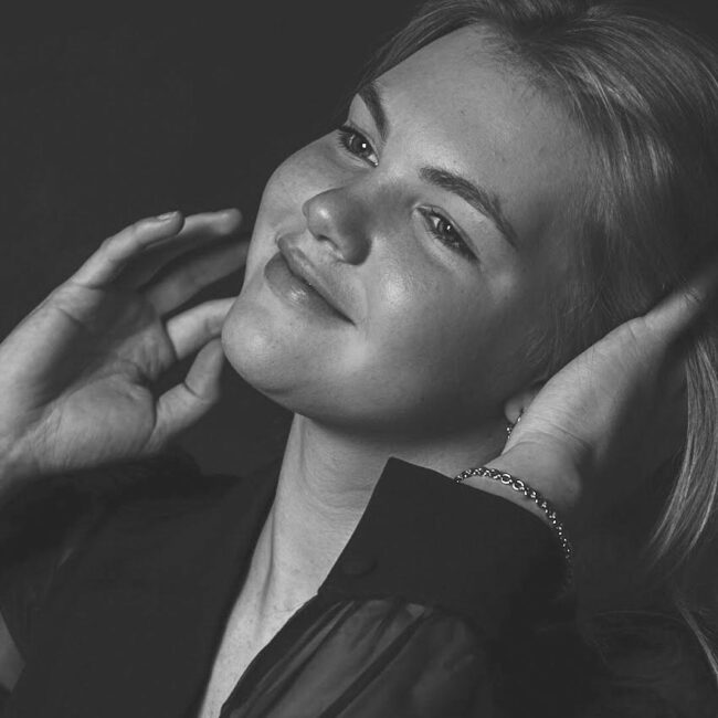 Studio fotograaf maakt een sfeervol zwart-wit portret van een vrouw met zachte belichting en een tijdloze uitstraling.